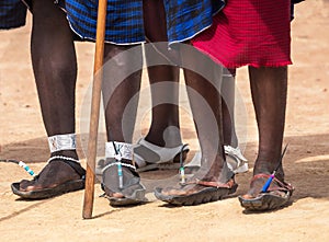 Feet three men of the Masai Mara tribe & x28;indigenous tribe of Kenya& x29;. Recycled rubber tires become Masai`s sandals photo