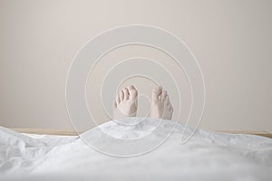Feet toes showing in bed lazy tired relaxed asleep pale background