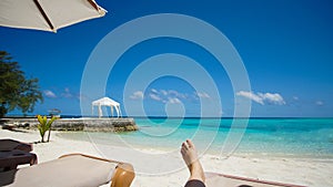 Feet tourist relax at Maldives turquoise sea white sand tropical beach paeadise