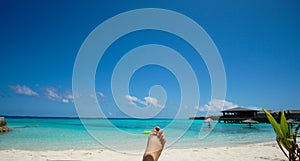 Feet tourist relax at Maldives turquoise sea white sand tropical beach paeadise