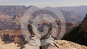 Feet Of A Tourist In Trekking Boots Resting On The Top Of The Grand Canyon