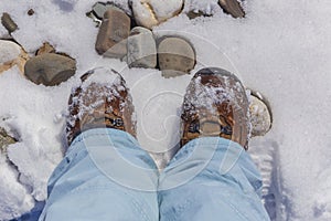 Feet in trekking boots in the snow