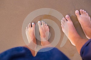 Feet of two lovers on sand-summer, sun, sea, beach.