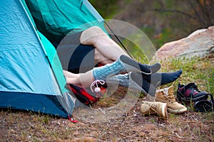 Feet of two people lying in a tent. Camping, travel, tourism, hike and people concept