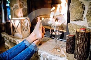 Feet of unrecognizable woman in front of the fireplace.