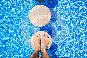 Feet of a vacationer relaxing in a pool