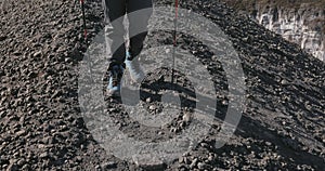 Feet walk on the frozen lava of an active volcano.