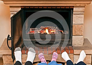 Feet warming at a fireplace