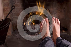 Feet warming at a fireplace