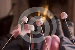 Feet warming at a fireplace with marshmallows