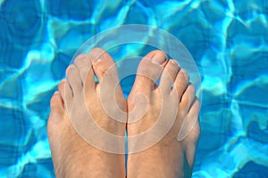 Feet in water on swimming pool