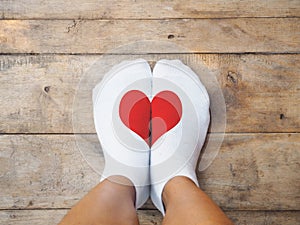 Feet wearing white socks with red heart shape