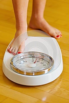 Feet of a woman on bathroom scales