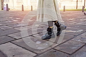 feet of woman in a black shoes on the city street on cold day