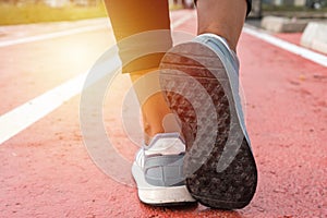 The feet of the woman runner running on the track. Female fitness model, jogging training. Healthy lifestyle concept in sport