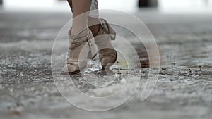 Feet of woman shod trendy ankle boots, sitting on swing, closeup view