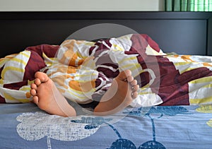 Feet of a woman sleeping on the bed