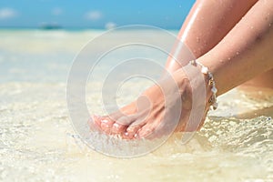 Feet of a woman in the spray of clean sea water.