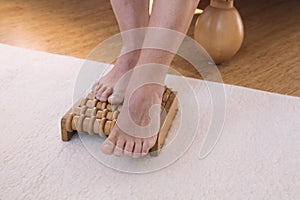 Feet on wooden massage roller