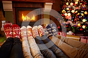 Feet in wool socks near fireplace in Christmas time