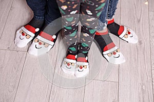 Feet in wool socks near fireplace in winter. Closeup image of family in warm knitted socks lying next to fireplace