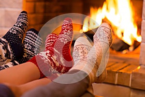 Feet in wool socks near fireplace in winter
