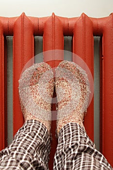 Feet with wool socks warming on the radiator