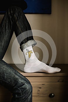 Feet in woollen socks. Man is relaxing with a cup of hot drink and warming up his feet in woollen socks.