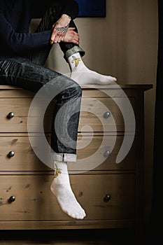 Feet in woollen socks. Man is relaxing with a cup of hot drink and warming up his feet in woollen socks.