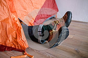 Feet in woollen socks. Man is relaxing near tent and warming up his feet in woollen socks.