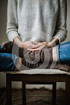 Feet in woollen socks. Woman is relaxing with a cup of hot drink and warming up her feet in woollen socks.