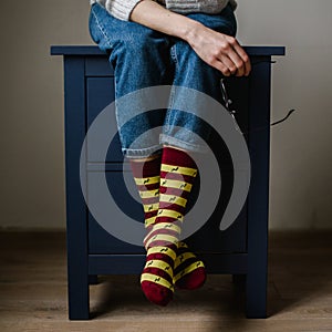 Feet in woollen socks. Woman is relaxing with a cup of hot drink and warming up her feet in woollen socks.