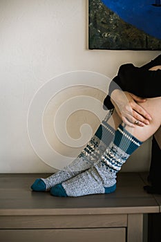 Feet in woollen. Woman and warming up her feet in woollen socks. Close up on feet.