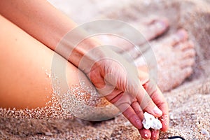 Feet of a young girl in the sand by the ocean closeup