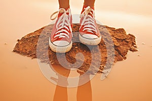 Feet of young girl standing in ground and water