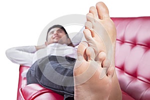 Feet of young man lying on couch