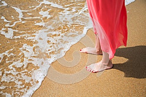 Feet of a young woman on a sandy beach