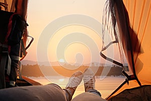 Feet of young women relaxing with lake view from tent camping entrance outdoor. Travel wanderlust lifestyle concept