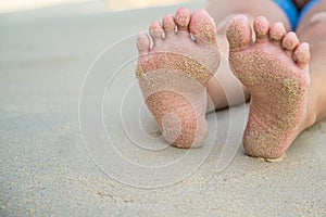 Feets with sand of lady sit on the beach
