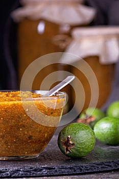 Feijoa jam in a glass bowl with green feijoa fruits. Natural homemade dessert. Rural still life