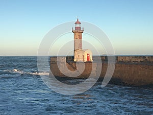 Felgueiras Lighthouse on the stone pier against the backdrop of a blue sky. Porto, Portugal