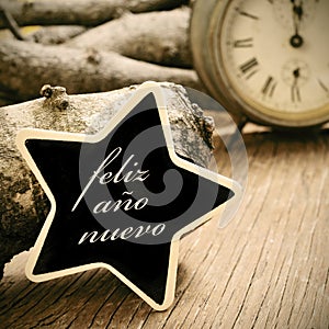 feliz ano nuevo, happy new year in spanish, in a star-shaped chalkboard, in sepia tone photo