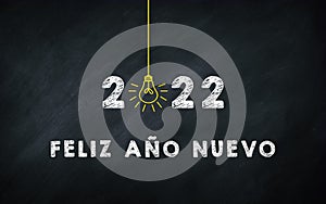 Feliz AÃÂ±o Nuevo 2022. Happy New Year in Spanish Idiom On chalkboard. Creative Concept. 2022 Light Bulb On Blackboard with Spain