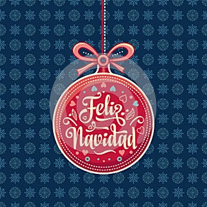 Feliz Navidad. Red Christmas ball with good wishes in Spanish.