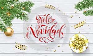 Feliz Navidad Spanish Merry Christmas holiday golden decoration on Xmas tree, calligraphy font for greeting card white wooden back