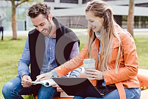 Fellow students looking into a book on college campus