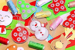 Felt Christmas ornaments group. Colorful felt snowman, deer, Christmas tree, ball crafts, polyester felt sheets, thread, needle