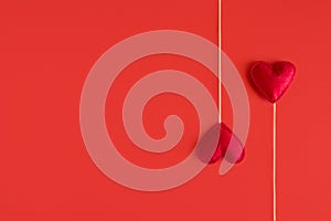 Felt love hearts on booth props on red paper background. Valentine`s day celebration concept. Top view. Flat lay. Copy space