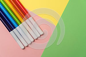 Felt-tip pens of all colors of the rainbow on a background of colored paper. Education or kids creativity concept