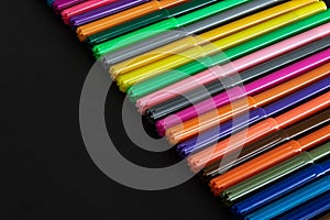 Felt tip pens in a row on black background